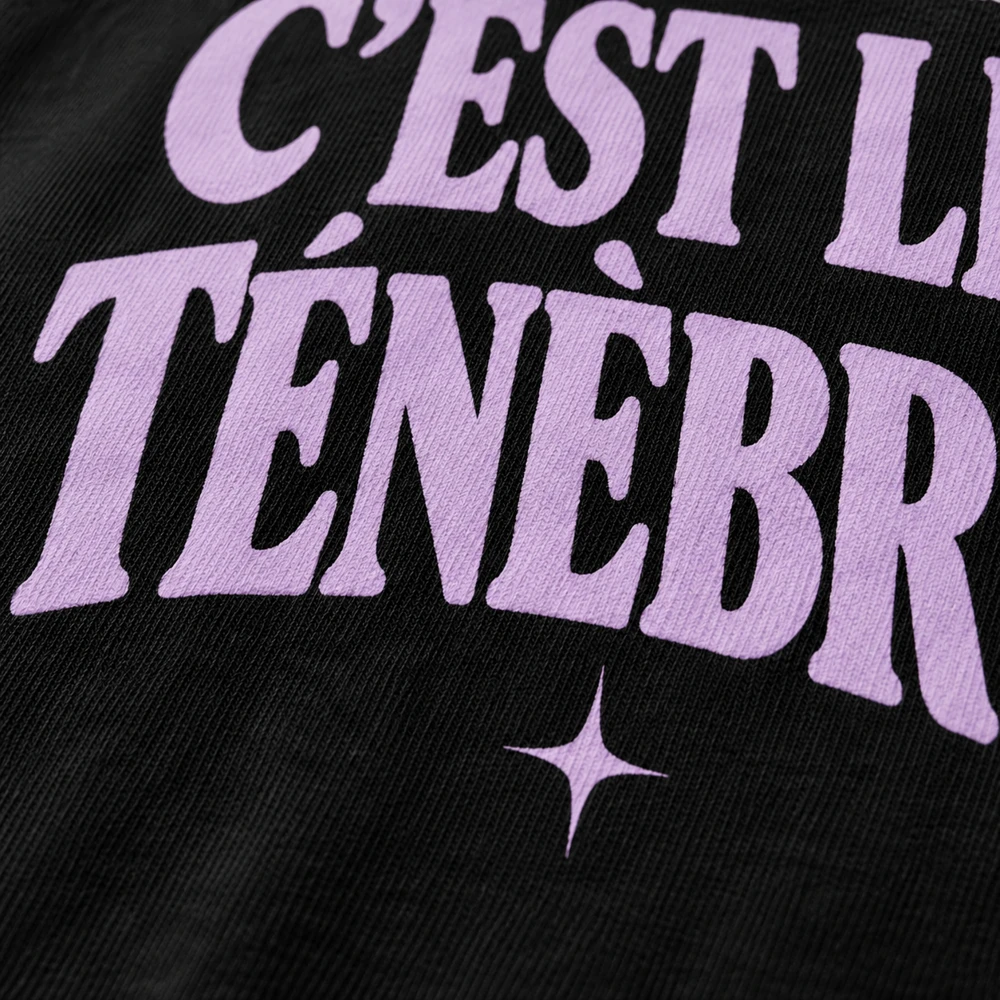 Concept de marquage lilas sur tissu noir, détail du slogan Les ténèbres